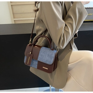 Detail of vintage patchwork crossbody bag with denim fabric and brown leather accents