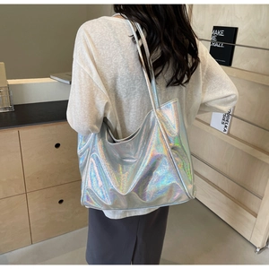 Holographic silver large capacity tote bag with long straps shown on a model back view