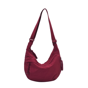 Deep red nylon crescent crossbody bag with wide adjustable strap and zipper details