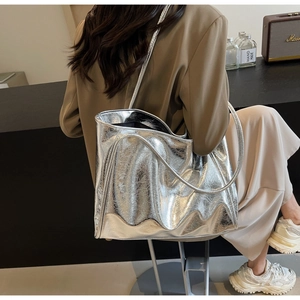 Detail of silver tote bag with metallic crinkle texture and spacious shoulder strap