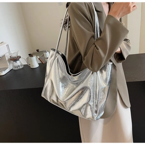 Detail showing metallic silver tote bag with natural wrinkles and minimalist design