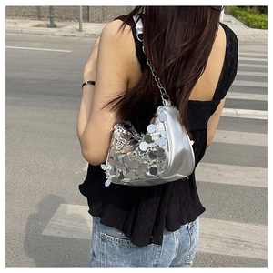 Dettaglio della borsa a spalla con paillettes argento e catena su una modella