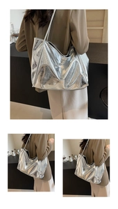 Macro detail of large silver tote bag showing metallic texture and wrinkled PU leather finish