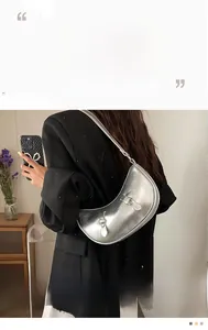 Detail of silver crescent shoulder bag with metallic cracked texture and buckle straps
