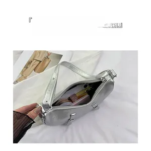 Spacious interior of silver crescent bag showing storage for phone and cosmetics