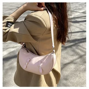 Pink minimalist saddle bag on shoulder of model in beige suit for street style