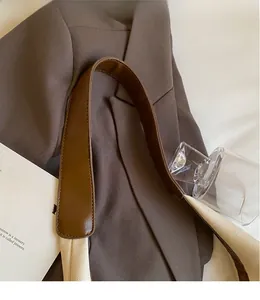 Détail de la large bandoulière bicolore en cuir marron et tissu tissé de couleur crème