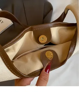 Gros plan détaillé du fermoir magnétique doré sur un sac à main rétro en toile durable