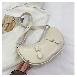 Detail of cream crescent hobo bag with silver rivets and wide adjustable strap