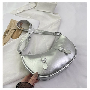 Silver crescent moon shoulder bag with metallic wrinkled texture and decorative buckles