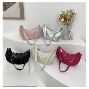Chic crescent shoulder bags in five colors displayed on a minimalist white pedestal