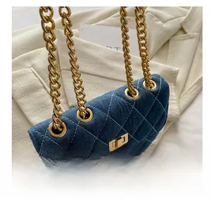 Detail view of denim crossbody bag with gold chain strap and diamond quilted stitching