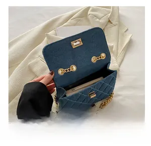 Blue denim quilted bag with gold chain strap showing interior capacity for a smartphone