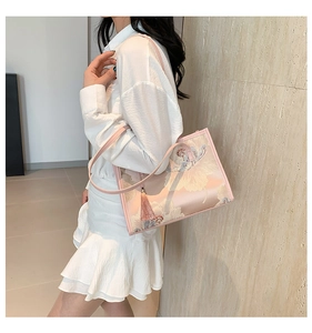 Detail of pink silk tote bag with floral embroidery and hanging tassel ornament