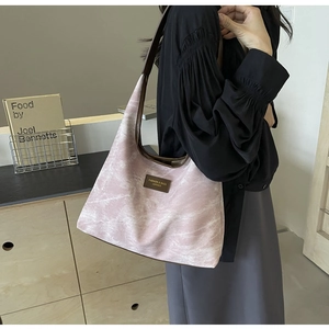Détail du sac à bandoulière à motif marbre rose avec lanière brune sur modèle femme