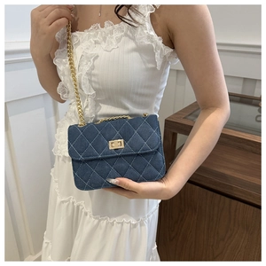 Close-up of quilted denim crossbody bag with gold chain strap worn by a model