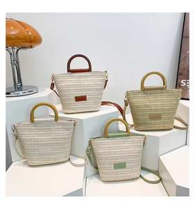 Collection of four woven bucket bags in neutral tones with round handles and long straps