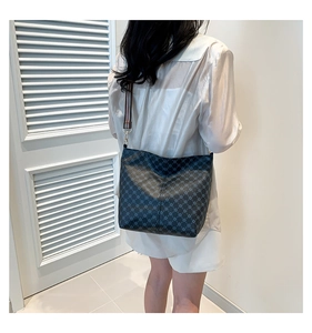 Detail of the bucket bag's geometric pattern and red-blue-white striped woven strap