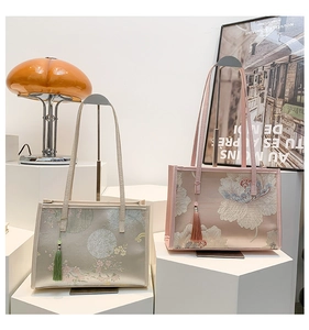 Detail view of embroidered tote bags with silk finish and elegant tassels on display