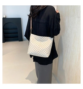 Detail of vintage patterned bucket bag showing the wide fabric strap and PU leather texture