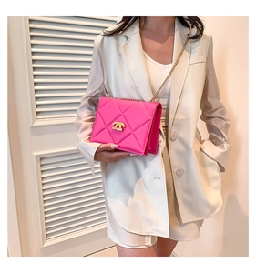 Model wearing rose pink quilted crossbody bag with gold chain strap and metal buckle