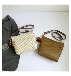 Detail of vintage tote bags with star pattern and fuzzy charm in cream and brown