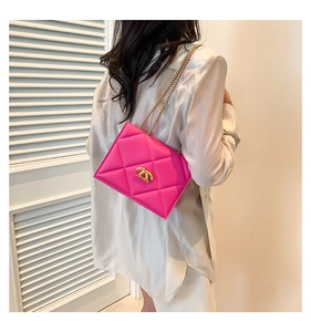 Detail of hot pink quilted shoulder bag with gold chain strap and metal clasp