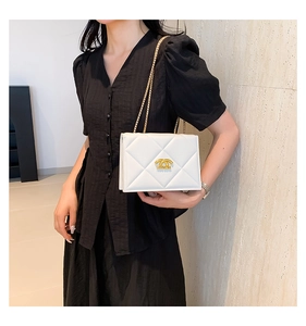 Close-up of white quilted leather flap bag with gold chain and logo for women