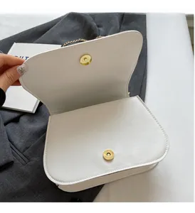Détail du sac bandoulière en cuir PU blanc avec fermoir magnétique et dorures