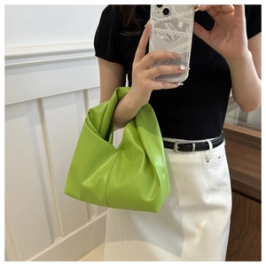 Dettaglio della borsa a mano in PU verde neon con design a pieghe e manico annodato