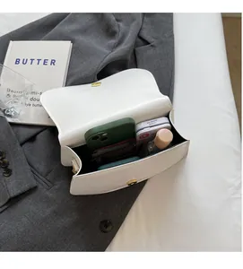 Vue intérieure montrant la grande capacité du sac bandoulière blanc avec des objets