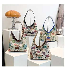 Four vintage floral brocade shoulder bags displayed on an artistic boutique pedestal