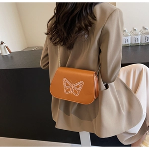 Vue détaillée du sac selle orange vintage avec broderie papillon et chaîne dorée