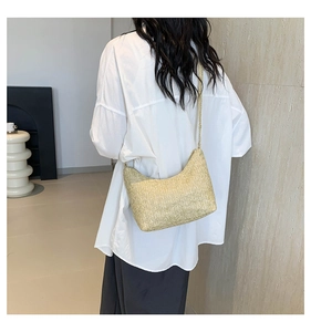 Détail du sac à bandoulière en paille tressée avec texture en V sur un sac Hobo crème