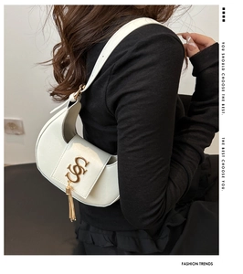 Détail du sac bandoulière blanc en demi-lune avec logo doré et fines chaînes frangées