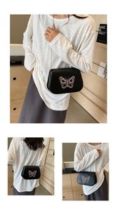 Détail du sac besace noir avec broderie papillon rose et bandoulière en chaîne dorée