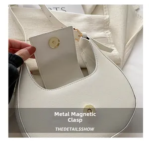 Détail macro du fermoir magnétique et de la texture cuir du sac croissant crème