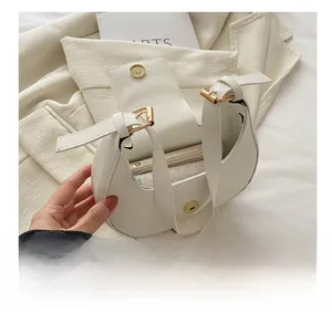 Vue détaillée d'un sac porté épaule blanc en demi-lune avec fermoir magnétique doré et rangement