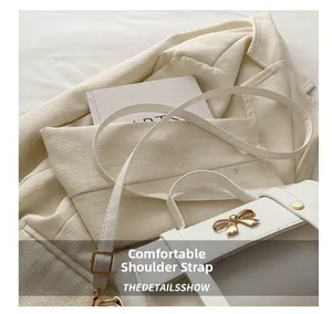 Detail view of the elegant golden bow buckle and comfortable white faux leather strap