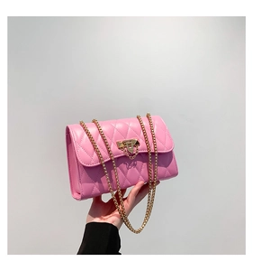 Macro detail of pink quilted leather texture and gold metal buckle on crossbody bag