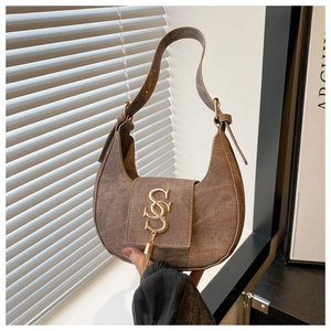 Détail du sac demi-lune marron vintage avec boucle dorée en S et glands métalliques