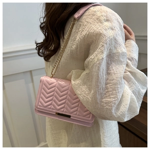 Pink quilted shoulder bag with gold chain strap shown on model for daily style