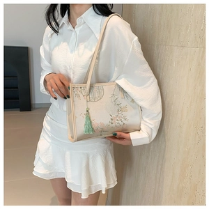Elegant off-white silk tote bag with vintage floral patterns and green tassel charm