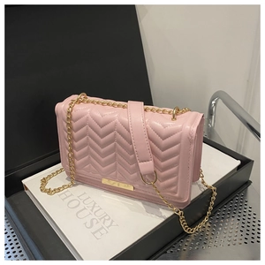 Detail of pink chevron quilted texture and elegant gold chain strap on small square bag