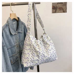 Détail d'un sac cabas en toile à fleurs avec cordon de serrage et motif floral violet