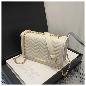 Detail of cream V-quilted texture and gold metal bar on chain shoulder bag