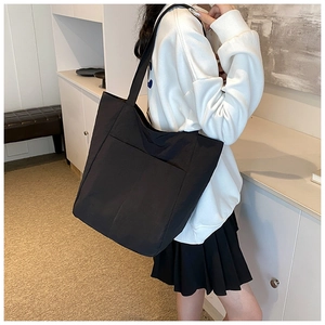 Black large capacity nylon tote bag shown on model for daily commuting and school use