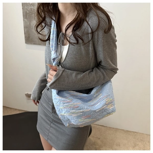 Detail of light blue dumpling bag with colorful wave embroidery and knotted strap