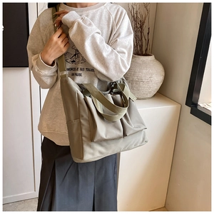 Detail of multi-pocket nylon tote bag with wide fabric shoulder strap for comfort