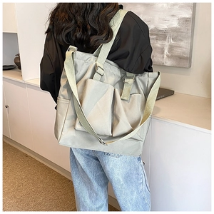 Detailed view of spacious nylon tote bag with dual front pockets and adjustable strap
